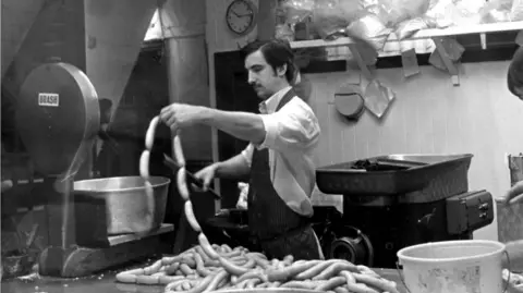 Dicksons Black and white picture of a man making sausages