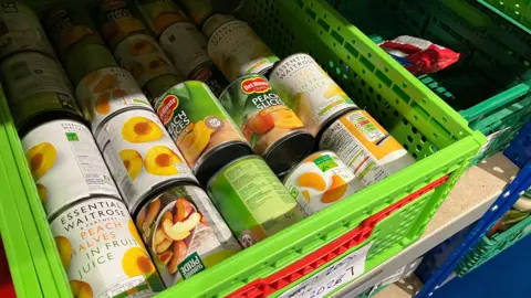 Thame Foodbank Tins of peach slices in a green tray
