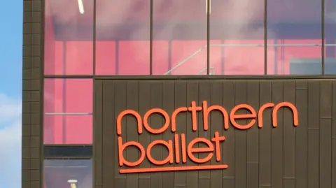 Getty Images A brown office building with 'Northern Ballet' written in orange signage. Below a sign reads: Phoenix Dance Theatre. 