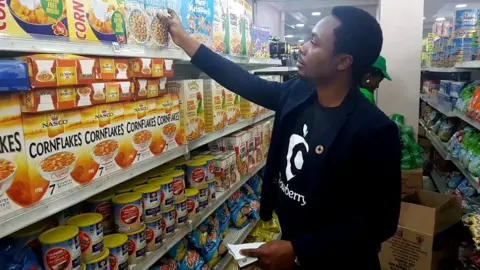 BBC Oscar Ekponimo looking at boxes of cereal