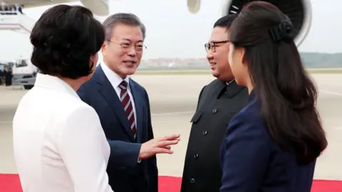 Getty Images Kim Jung-sook, Ri Sol-ju, Moon Jae-in and Kim Jong-un embrace at the airport