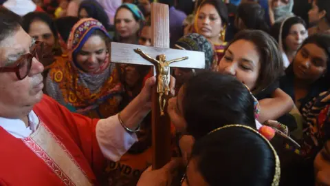 AFP Pakistani Christians devotees kiss a depiction of the crucifixion of Jesus during a Good Friday service at St Anthony's church in Lahore on April 19, 2019. (