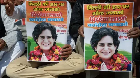 Getty Images Indian Congress party workers hold pictures of Priyanka Gandhi as they shout slogans outside the All Indian Congress Committee office in New Delhi on February 10, 2015, demanding Priyanka replace Congress party vice-president Rahul Gandhi to 'save the party'. Indian Prime Minister Narendra Modi conceded defeat on February 10 in the Delhi state elections as early results showed anti-corruption campaigner Arvind Kejriwal's party set for a landslide victory.