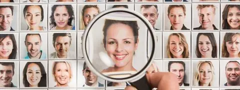 Conceptual image of a grid featuring photographs of multiple people, with a magnifying glass over a woman in the centre