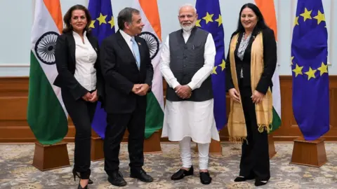PIB Delegation pose for picture in front of flags