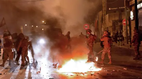 AFP Lebanese soldiers surround a burning motorcycle amid clashes between supporters of the Hezbollah and Amal movements and anti-government protesters in Beirut on 25 November 2019