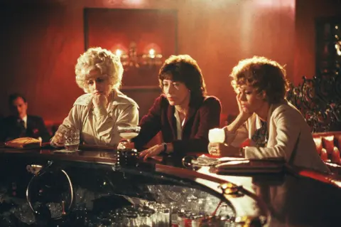 Shutterstock Dolly Parton, Lily Tomlin and Jane Fonda drown their sorrows in a scene from 9 to 5