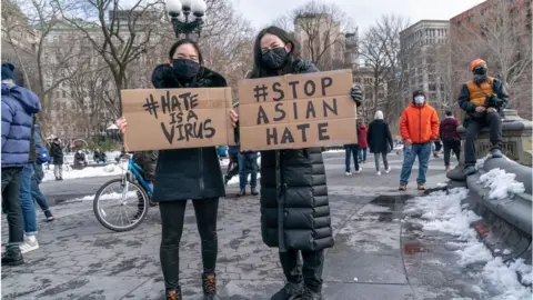 Getty Images Two people holding stop Asian hate signs