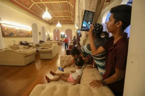 EPA People take photos inside the president's palace, in Colombo, Sri Lanka, 12 July 2022