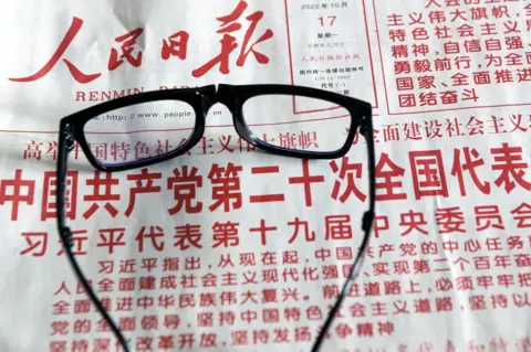  CFOTO/Future Publishing  A citizen reads a newspaper to learn about the report of the 20th Communist Party of China (CPC) Congress in Shenyang, Liaoning province, China, Oct 17, 2022.