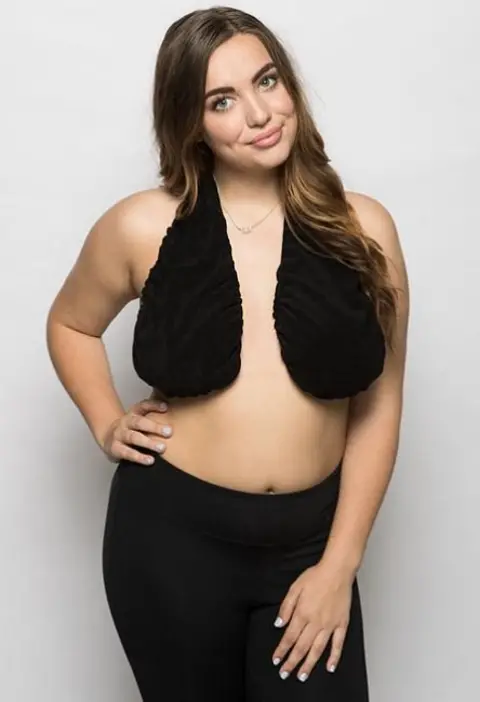 Tatatowel.com A woman poses in a black Ta-Ta Towel and black leggings