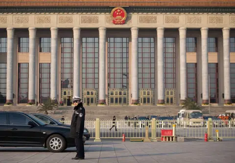 AFP/Getty Images A policeman stands guard outside the Great Hall of the People prior to the unveiling of a new Politburo Standing Committee, in Beijing on 15 November 2012.