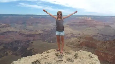 Macildowie  Woman standing on a rock by the Grand Canyon