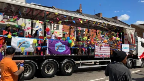 BBC/Peter Cooper Parade from previous carbinal showing colourful float with bunting