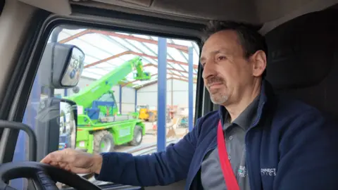 Joe Alves, a lorry driver in his lorry cabin.