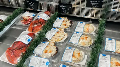 Maddy Jennings/BBC Rows of crabs and other seafood on a fish stall