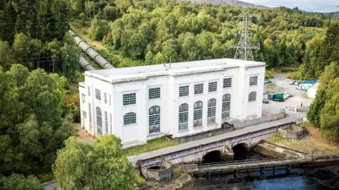 BBC Tummel hydro power station is a rectangular building with large windows on the banks of a river