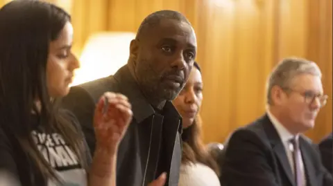 PA  Tanisha Dadar, the cousin of Ronan Kanda who was killed in 2022, actor Idris Elba, Yemi Hughes, whose 19-year-old son Andre Aderemi was murdered in 2016, and Prime Minister Sir Keir Starmer during a knife crime summit at Downing Street, London.