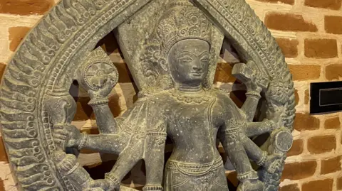 Sanjaya Dhakal / BBC Nepali Rabindra Puri with the replica of a Saraswati sculpture