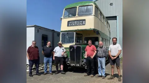 Ipswich Transport Museum Six gentlemen stand in front of a cream and green double-decker bus smiling. Its licence plate says EPV 24 and the destination sign reads 'Ipswich Station'