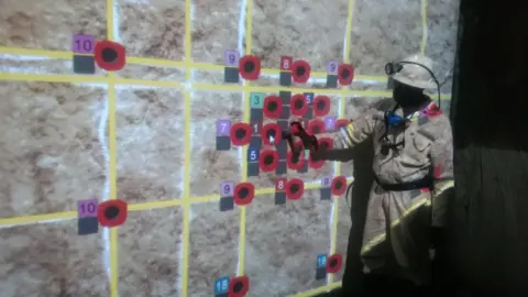 STS3D A trainee use an electronic "spray can" to mark out blast holes