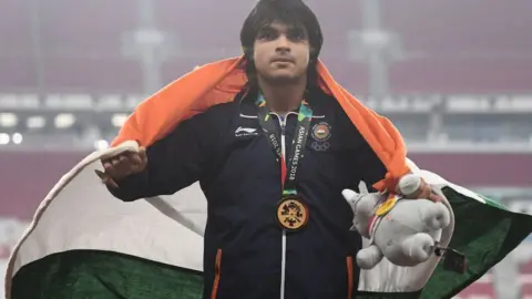 Getty Images Gold medallist India"s Neeraj Chopra celebrates during the victory ceremony for the men"s javelin throw athletics event during the 2018 Asian Games in Jakarta on August 27, 2018
