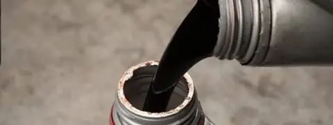 Oil being poured from one container to another