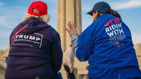 Getty Images Two women sitting - one a Trump supporter the other Biden supporter