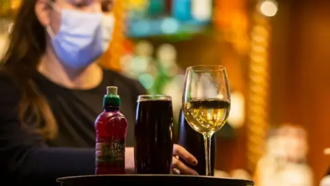 Getty Images A bar worker serves a mixture of alcoholic and non alcoholic drinks