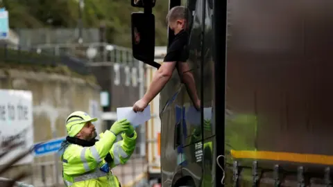 Reuters A lorry driver has a document checked