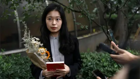 Reuters Zhou Xiaoxuan, also known by her online name Xianzi, speaks to supporters as she arrives at a court for a sexual harassment case involving a Chinese state TV host, in Beijing, China on 14 September 2021