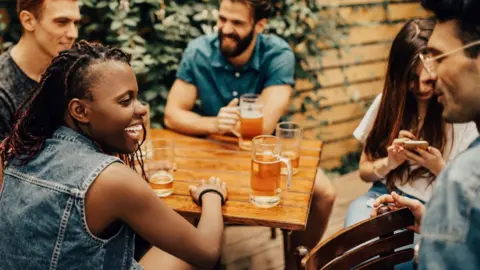 Getty Images Group of people drinking at pub