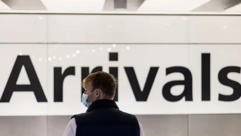 Reuters A man wearing a face mask is seen waiting at the arrival area of terminal 5, heathrow