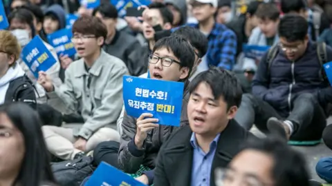 Getty Images South Korean men and a few women chant slogans during a protest against #MeToo