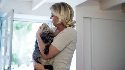 MARTIN BUREAU/AFP/Getty Images Marine Le Pen strokes her cat at her countryhouse on July 28, 2010