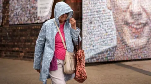 Getty Images Woman walking in the rain