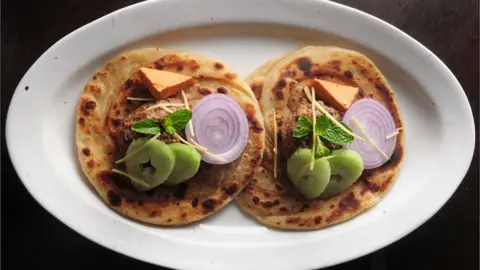 Getty Images : Picture showing special Lucknowi Bengali dish named, Ghutwan Kabab with Paratha served with ginger juliennes cucumber onion and smoked bandel Cheese, at Ta'aam Restaurant on February 20, 2015 in Kolkata, India. (
