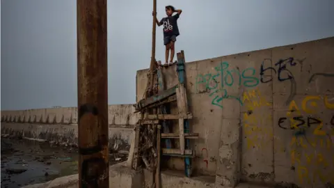 Jonas Gratzer A boy walks on the newly built sea wall that protects Jakarta from the rising sea levels