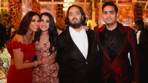 Reuters Akash Ambani and Anant Ambani, sons of Mukesh Ambani, the Chairman of Reliance Industries, pose with Shloka Mehta Ambani, wife of Akash, and Radhika Merchant, daughter of industrialist Viren Merchant, during pre-wedding celebrations of Anant and Radhika in Jamnagar, Gujarat, India, March 2, 2024.