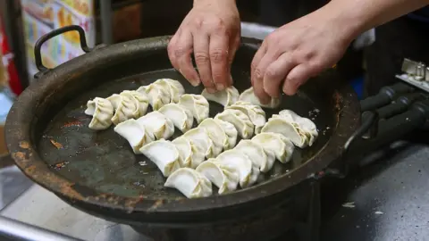 Getty Images A person cooking Japanese dumplings