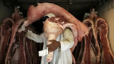 Reuters An employee carries pieces of meat at a butchery in Sao Paulo, Brazil October 10, 2014.