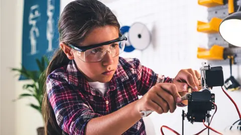Georgijevic / Getty Images Girl in a robotics laboratory adjusts the robot arm model