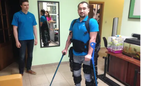 BBC A paralysed man wearing an ExoAtlet exoskeleton