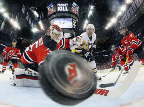 Bruce Bennett/ Getty Images A puck flies towards the camera.