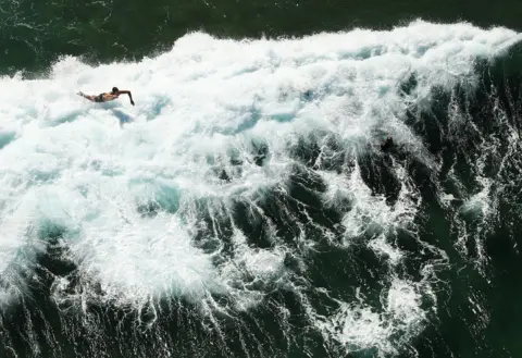 Ryan Pierse/ Getty Images A surfer falls into a wave