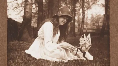 Getty Images/SSPL Young girl in a hat appears to gesture to a dancing gnome in a garden