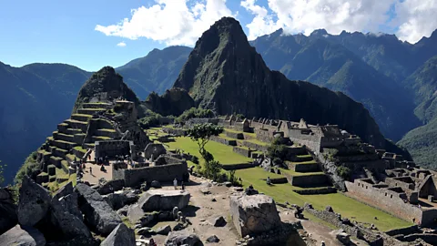 Cris Bouroncle/Getty Travellers walk among the ruins of Machu Picchu. (Credit: Cris Bouroncle/Getty)