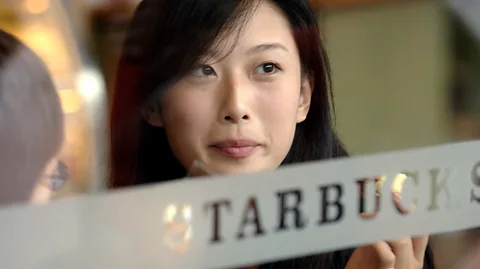 Joe McNally/Getty Images Wang Yili, fashion model in Beijing, has coffee at local Starbucks, Xidan District. Foreign companies and cultures have made huge inroads. (Credit: Joe McNally/Getty Images)