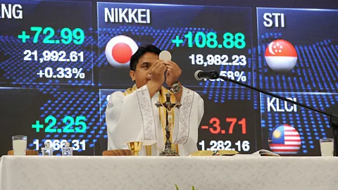 Getty Images A Roman Catholic priest officiates mass on the first day of trading at the Philippine Stock Exchange in Manila (Credit: Getty Images)