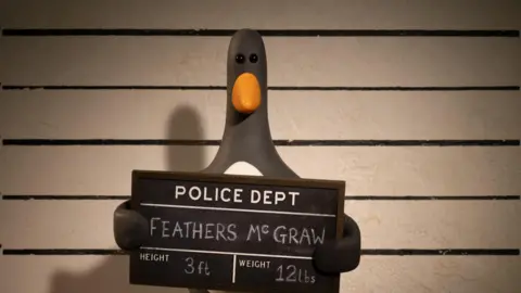 Aardman Animation An animated version of a penguin stands in front of the camera in the style of a police mugshot, holding a borad which identifies him as Feathers McGraw and his height as 3ft and weight 12 pounds. 